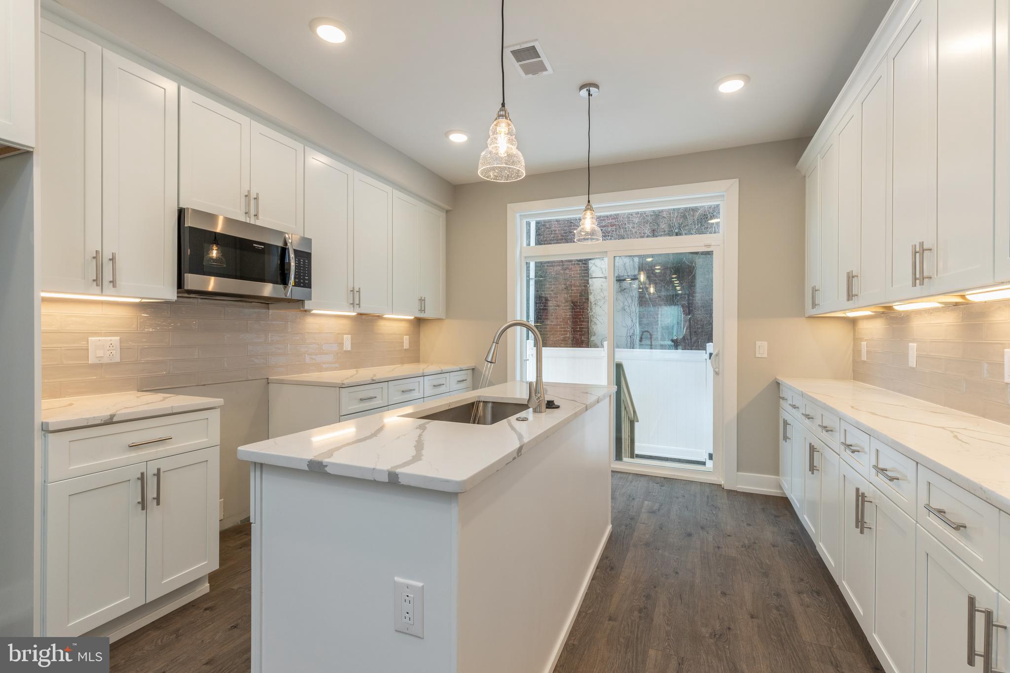 135 West Huntingdon Street, Unit 1 Philadelphia, PA 19133 - Photo 2 of 29 a kitchen with granite countertop a sink stove and cabinets