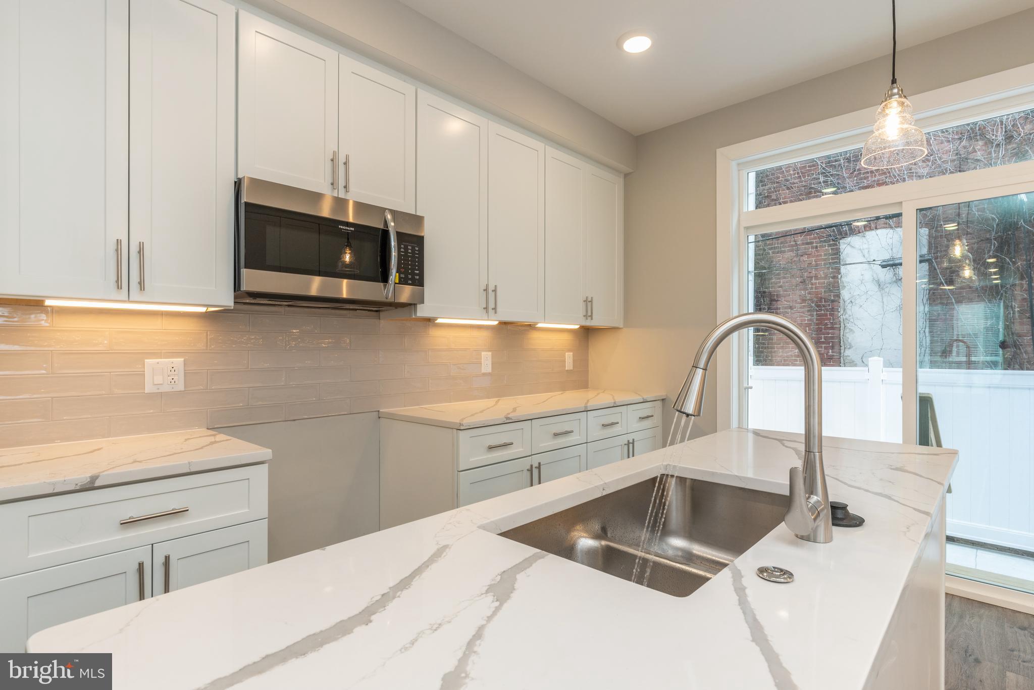135 West Huntingdon Street, Unit 1 Philadelphia, PA 19133 - Photo 3 of 29 a kitchen with stainless steel appliances a sink a stove and microwave