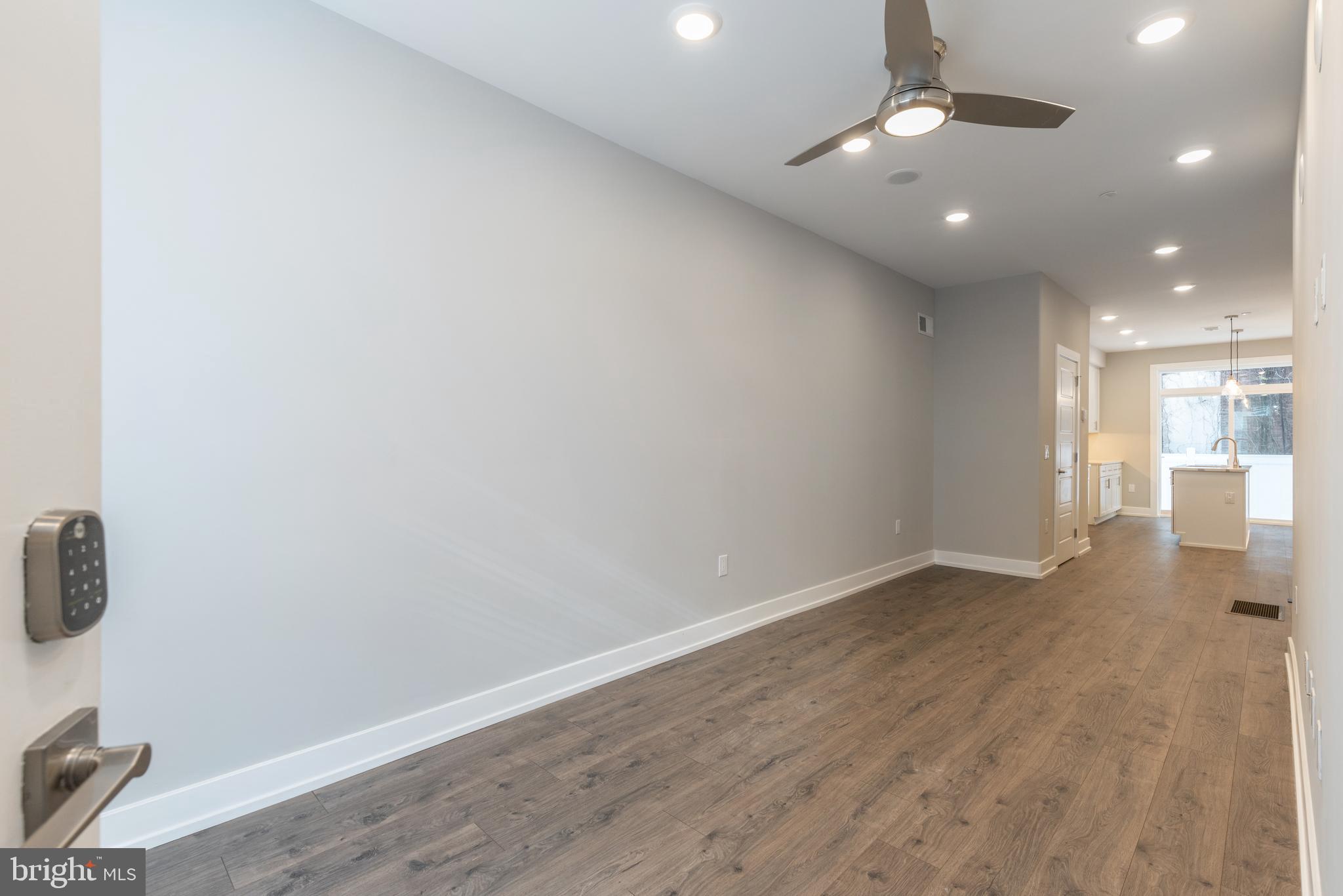 135 West Huntingdon Street, Unit 1 Philadelphia, PA 19133 - Photo 4 of 29 an empty room with wooden floor and windows