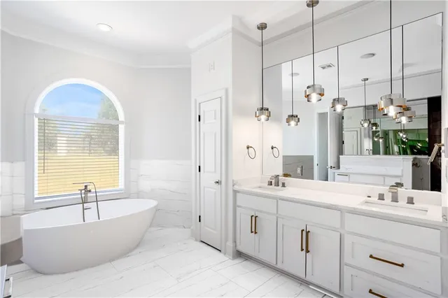 a bathroom with a tub sink double vanity granite and shower