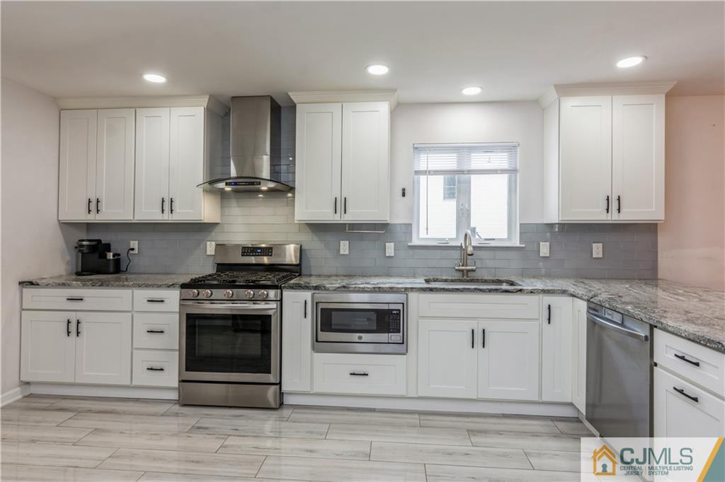 31 Hancock Road Piscataway, NJ 08854 - Photo 4 of 29 a kitchen with stainless steel appliances granite countertop a stove and white cabinets