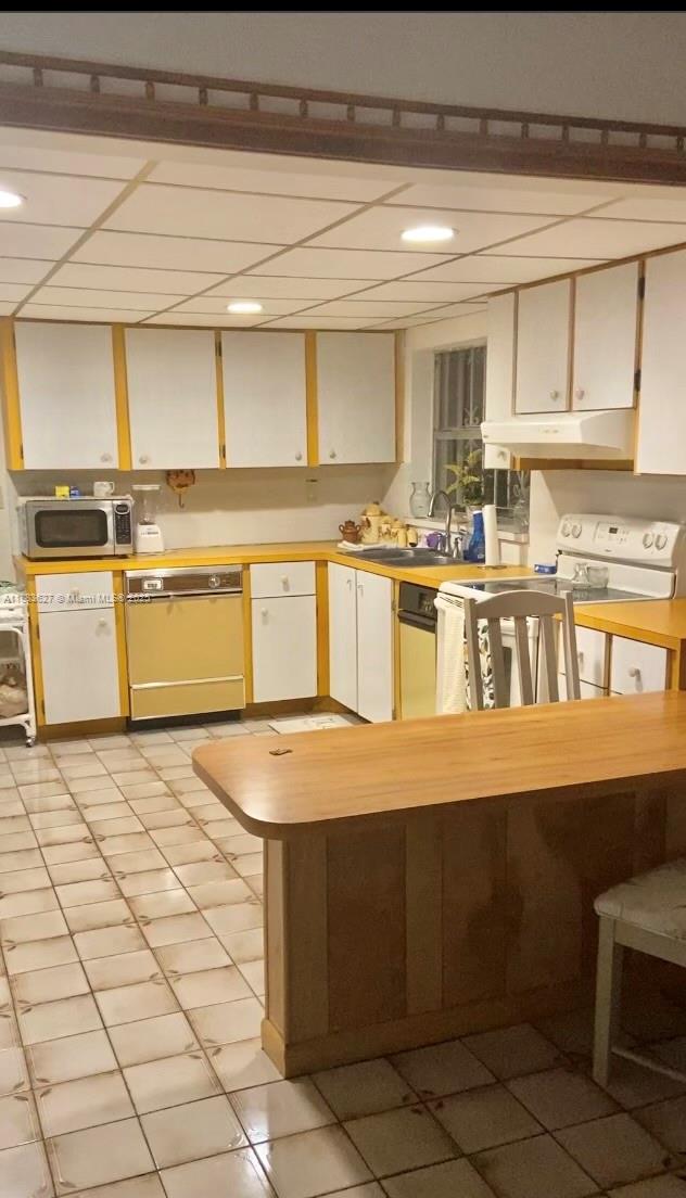8947 Southwest 12th Street Miami, FL 33174 - Photo 4 of 4 a kitchen with a stove a sink and cabinets