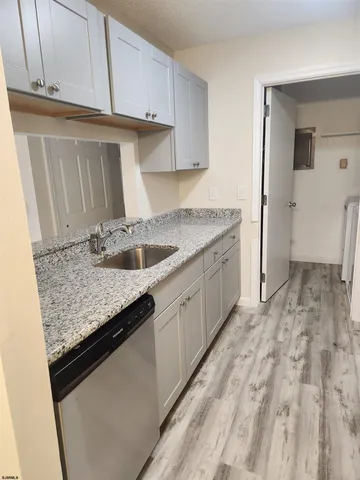 a kitchen with granite countertop a sink and a stove