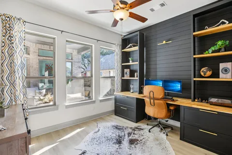 a view of a workspace with furniture and a window