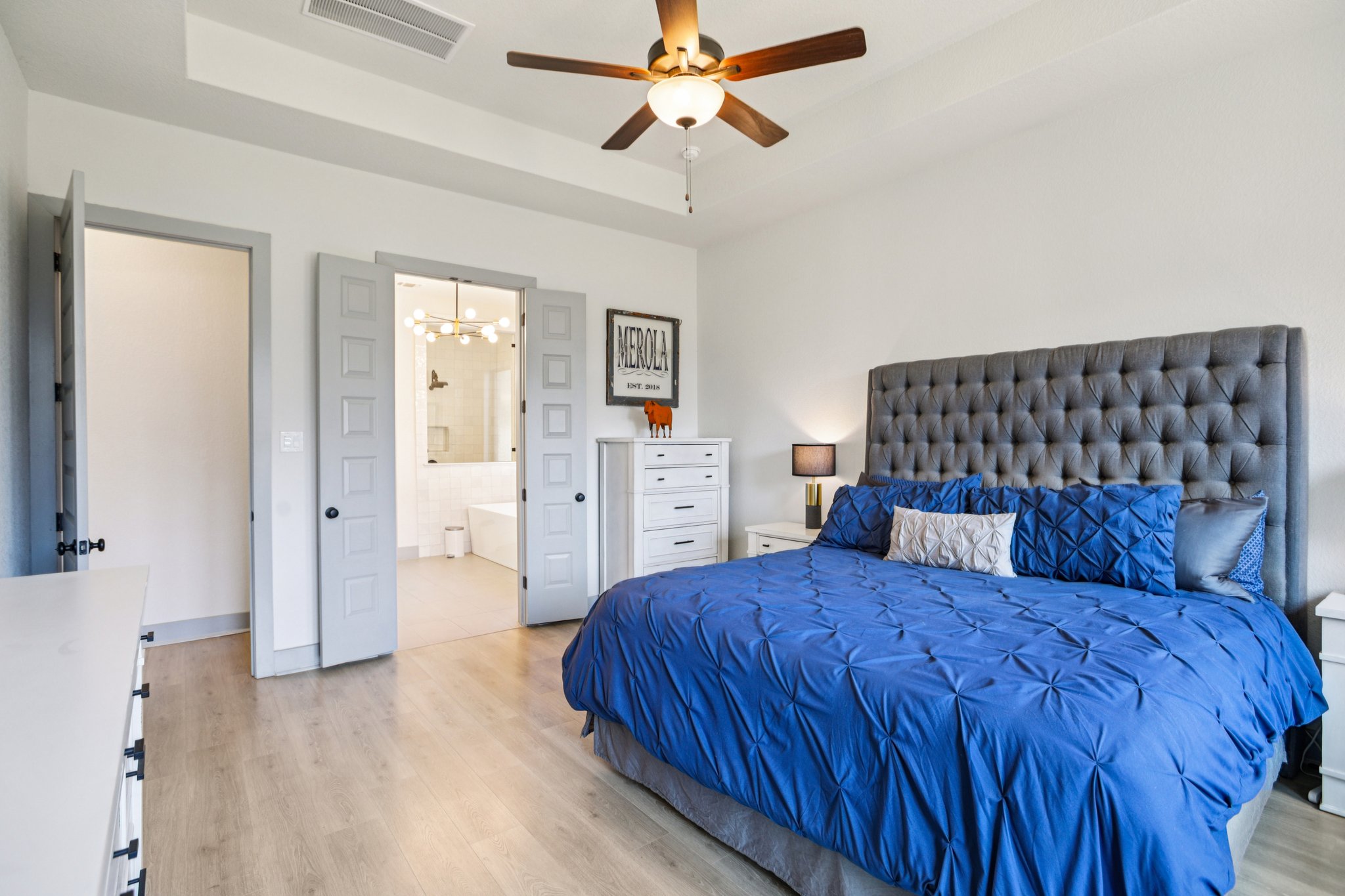 133 Lake Spring Circle Georgetown, TX 78633 - Photo 13 of 31 a bedroom with a large bed and a chandelier