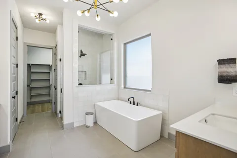 a white bath tub sitting next to a bathroom sink
