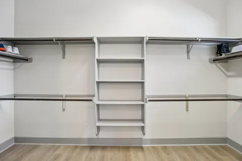 a view of walk in closet with empty racks