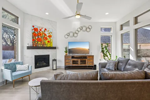 a living room with furniture a fireplace and a large window