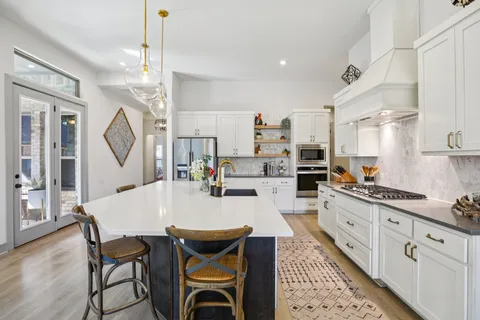 a large kitchen with kitchen island a large island in it