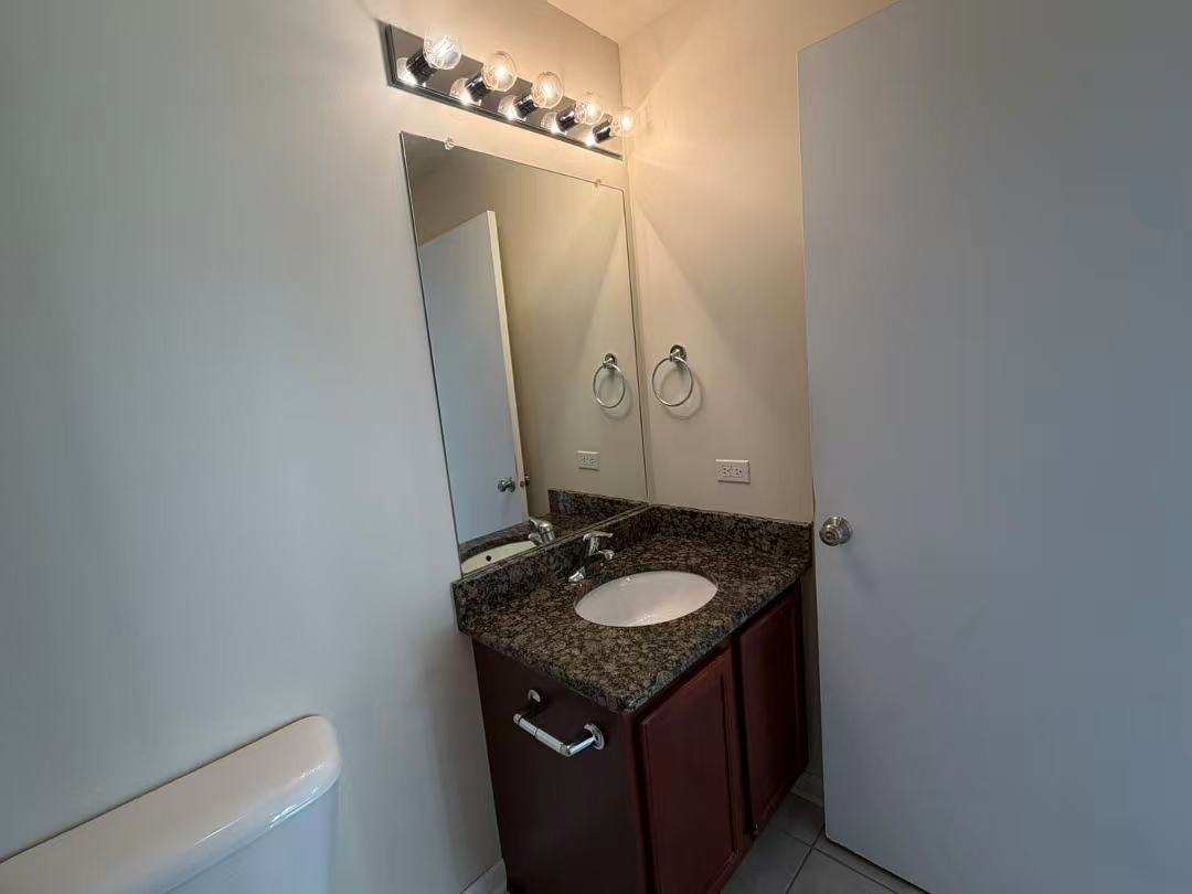 8255 Skokie Boulevard, Unit 406 Skokie, IL 60077 - Photo 14 of 16 a bathroom with a granite countertop sink and a mirror