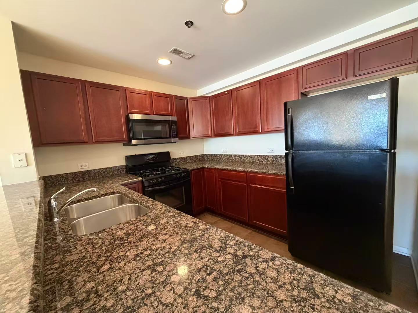 8255 Skokie Boulevard, Unit 406 Skokie, IL 60077 - Photo 3 of 16 a kitchen with granite countertop a refrigerator and a sink