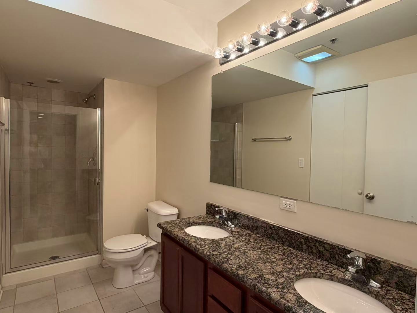 8255 Skokie Boulevard, Unit 406 Skokie, IL 60077 - Photo 10 of 16 a bathroom with a granite countertop sink toilet a mirror and shower