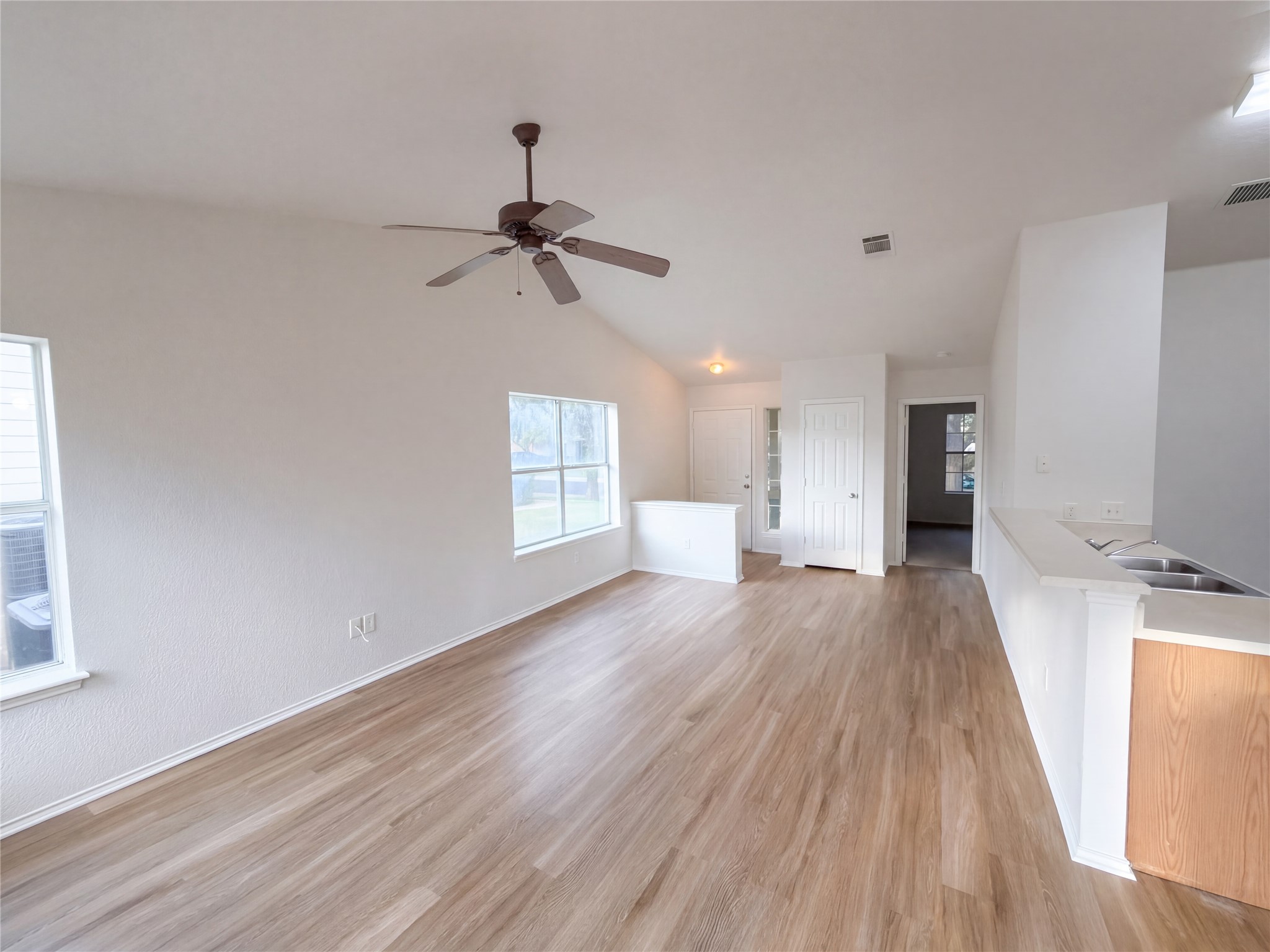 172 Prairie Springs Loop Georgetown, TX 78626 - Photo 27 of 32 Hardwood floors and vaulted ceilings elevate this open-concept main living space.
