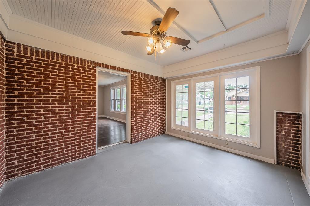 1500 Proctor Avenue Waco, TX 76708 - Photo 11 of 40 This room features exposed brick walls, a paneled ceiling, and a ceiling fan with integrated lighting