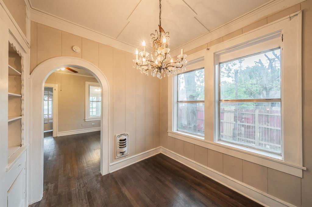 1500 Proctor Avenue Waco, TX 76708 - Photo 20 of 40 This room features dark hardwood flooring, two windows with white trim, and a decorative chandelier