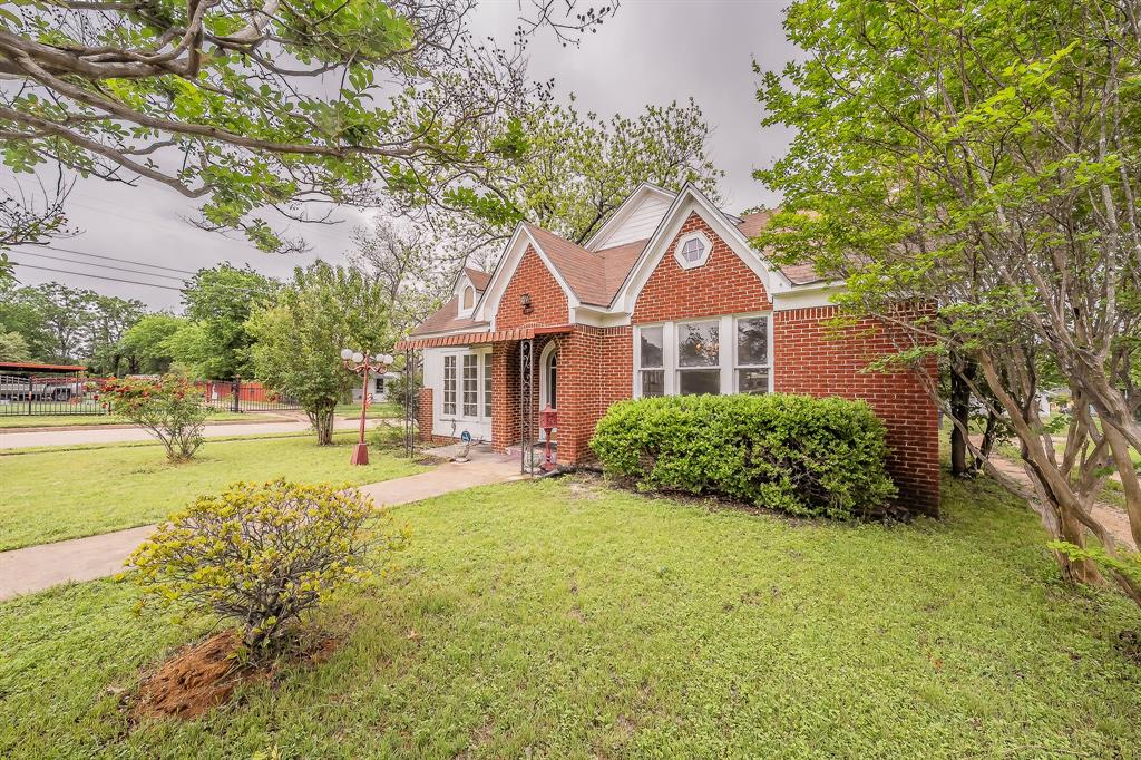 1500 Proctor Avenue Waco, TX 76708 - Photo 2 of 40 The property features a red brick facade with white trim, a gabled roof, and a mature lawn with established trees and shrubs