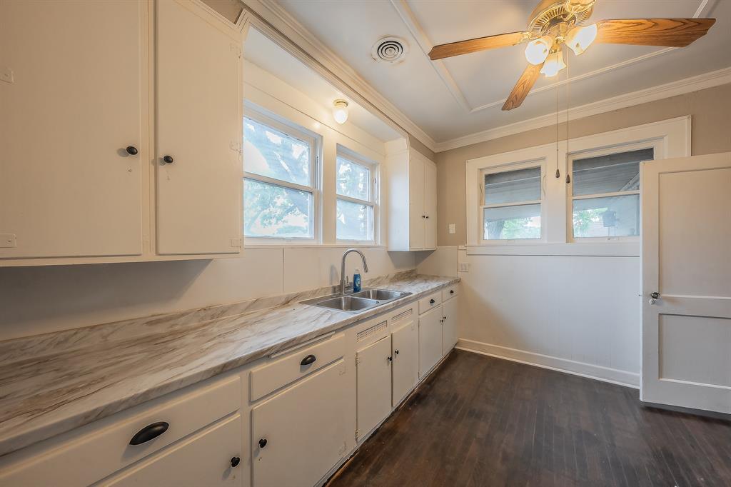 1500 Proctor Avenue Waco, TX 76708 - Photo 22 of 40 The kitchen features white cabinetry, a double basin sink, and a ceiling fan with light fixture
