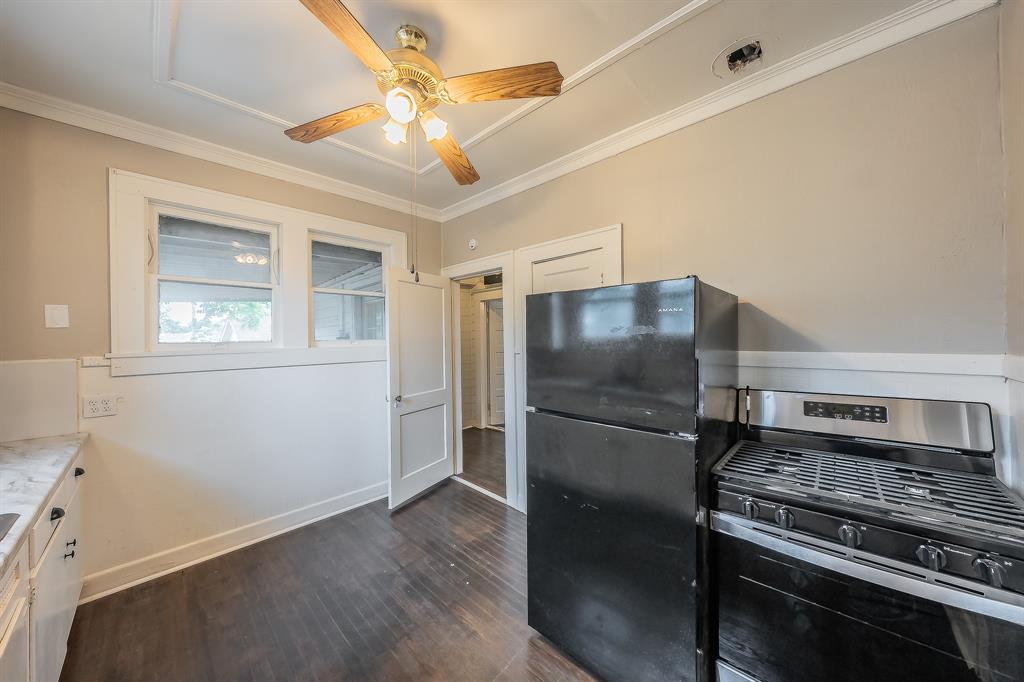 1500 Proctor Avenue Waco, TX 76708 - Photo 23 of 40 The kitchen features hard flooring, white cabinetry with a marble-style countertop, a black refrigerator, and a stainless steel and black range