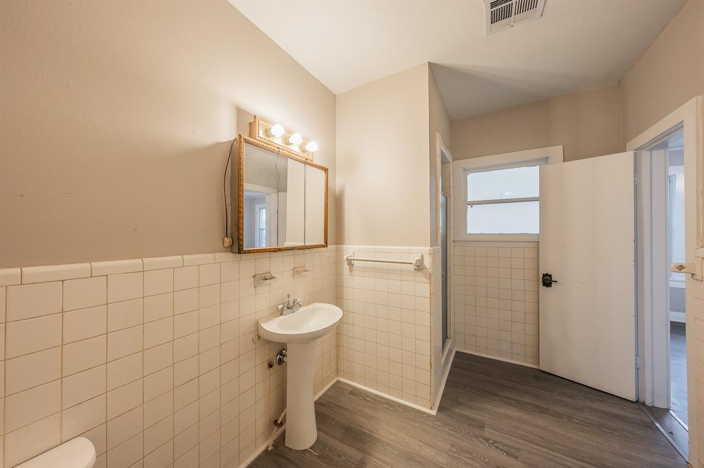 1500 Proctor Avenue Waco, TX 76708 - Photo 29 of 40 Bathroom featuring a pedestal sink, a medicine cabinet with vanity lighting, and tiled walls surrounding the shower area