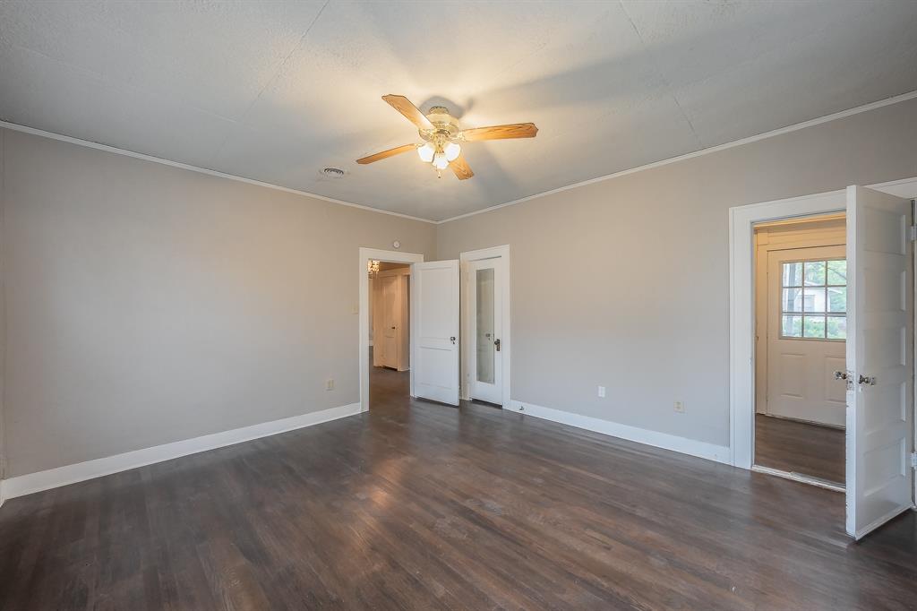 1500 Proctor Avenue Waco, TX 76708 - Photo 32 of 40 This room features dark hardwood flooring, light-colored walls, and a ceiling fan with light fixtures