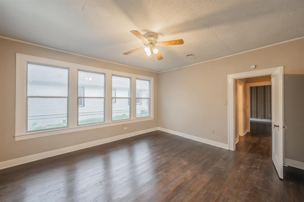 1500 Proctor Avenue Waco, TX 76708 - Photo 33 of 40 Spacious room featuring dark wood flooring, light-colored walls, and a ceiling fan with integrated lighting