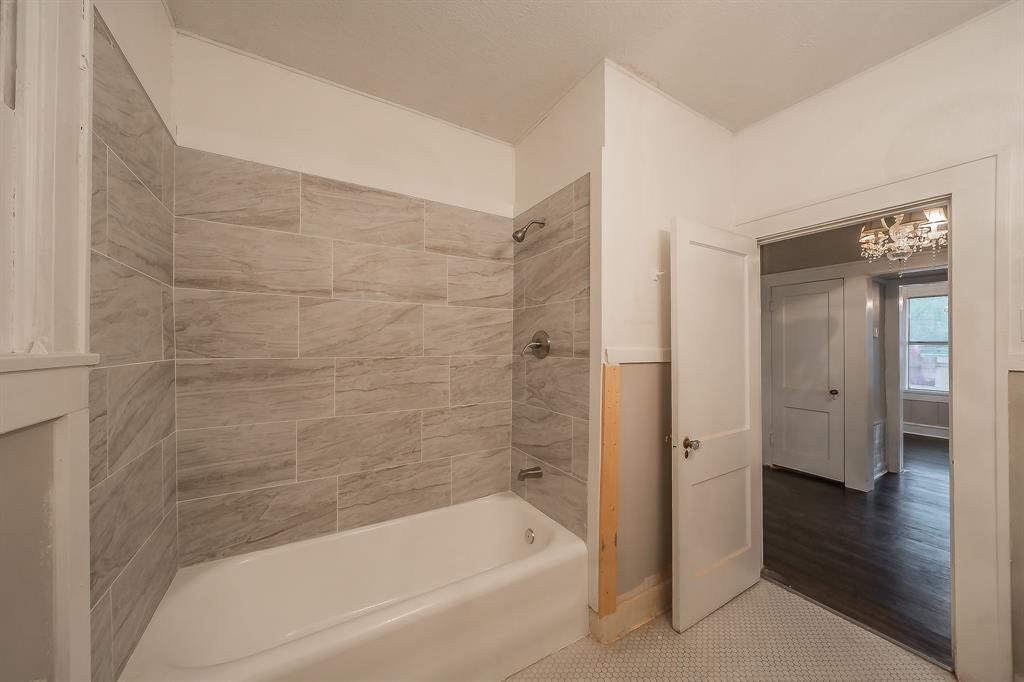 1500 Proctor Avenue Waco, TX 76708 - Photo 35 of 40 Bathroom featuring a white bathtub, light-colored tiled walls, and a tiled floor