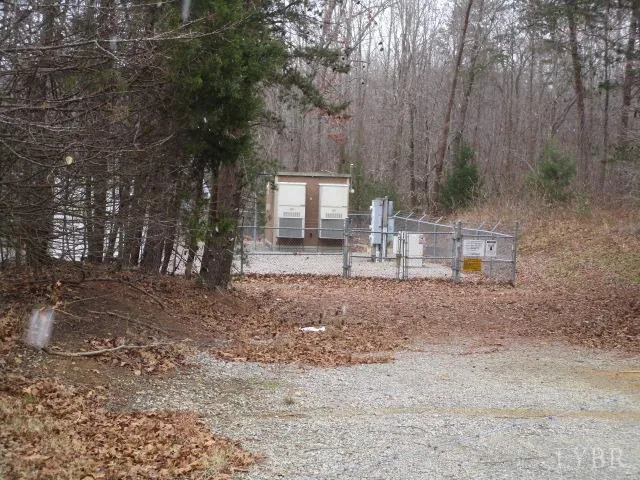a backyard of a house with large trees and wooden fence