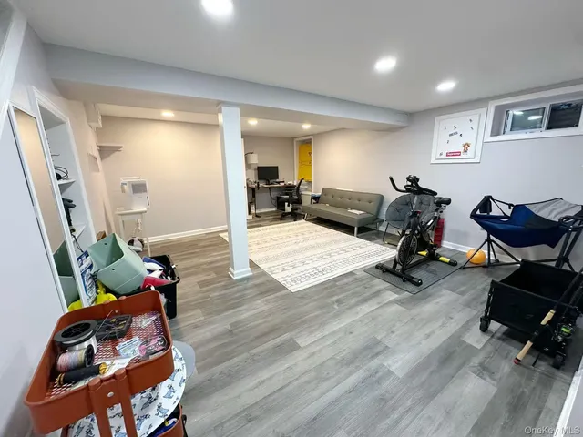 a living room with furniture hard wood floor and gym equipment