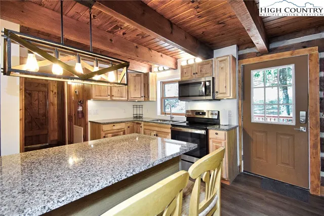 a living room with furniture a large window and a dining table