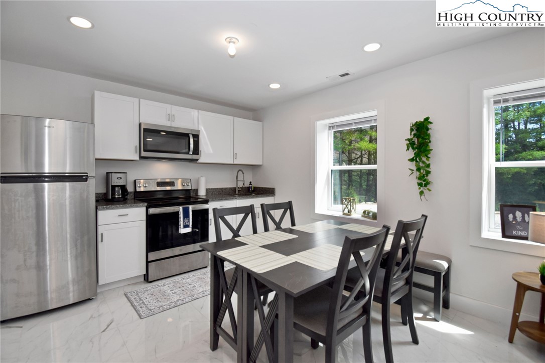 269 Willow Mountain Drive Vilas, NC 28692 - Photo 21 of 37 a kitchen with a table chairs refrigerator and microwave