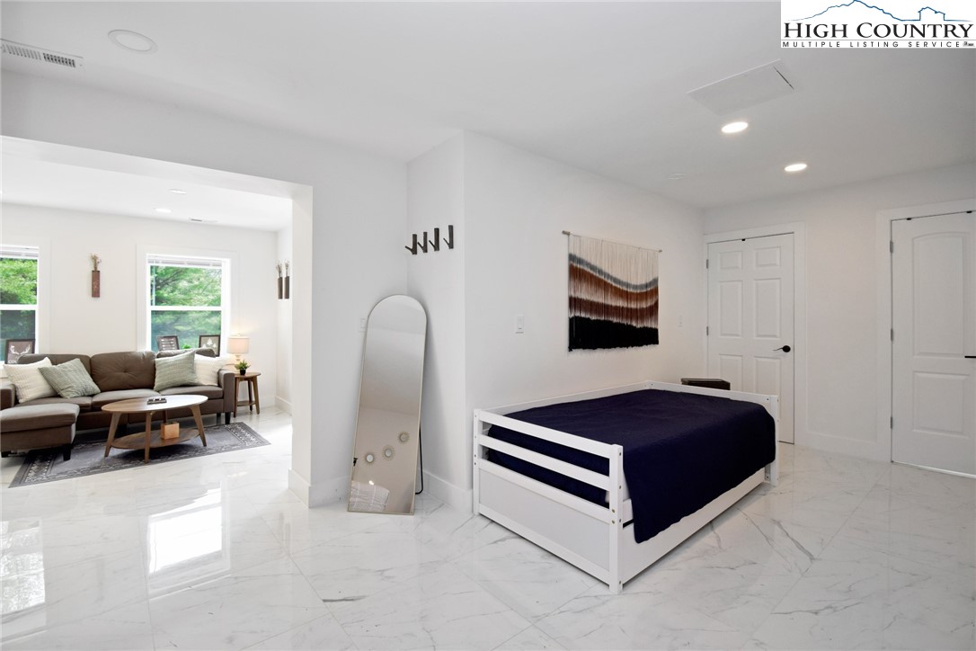 269 Willow Mountain Drive Vilas, NC 28692 - Photo 30 of 37 a spacious bedroom with a bed and a couch