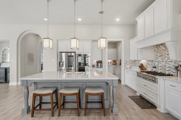 a kitchen with a sink stove and wooden floor