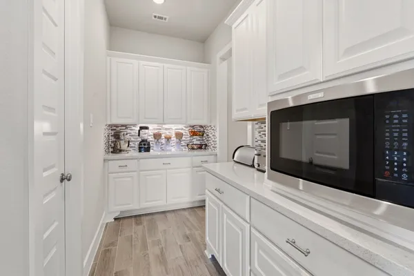 a spacious bedroom with a bed a couch and a chandelier
