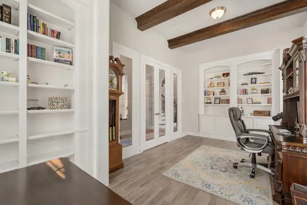 a dining room with wooden floor a chandelier a wooden table and chairs