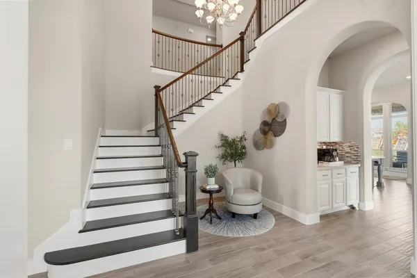 a kitchen with stainless steel appliances kitchen island granite countertop a table chairs sink and cabinets