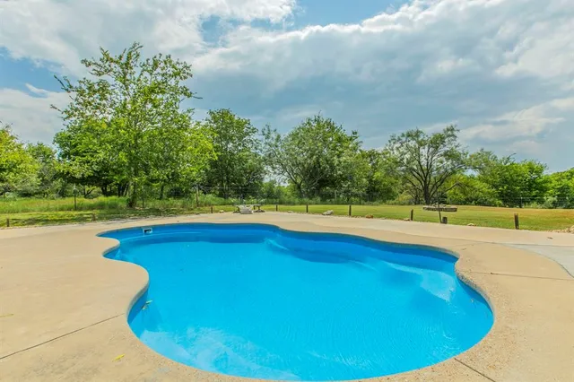 a view of an house with backyard and pool