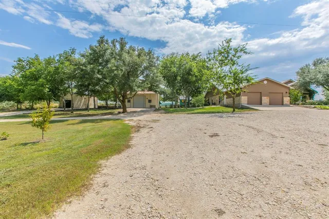 a view of a house with a big yard and basketball court