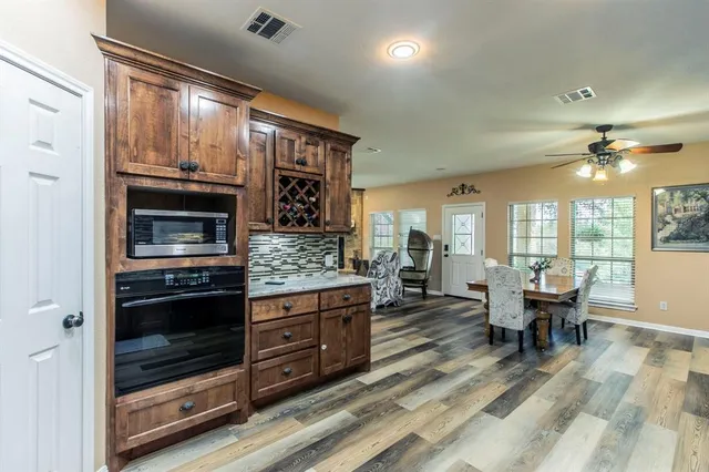 a kitchen with stainless steel appliances kitchen island granite countertop a refrigerator and a wooden cabinets