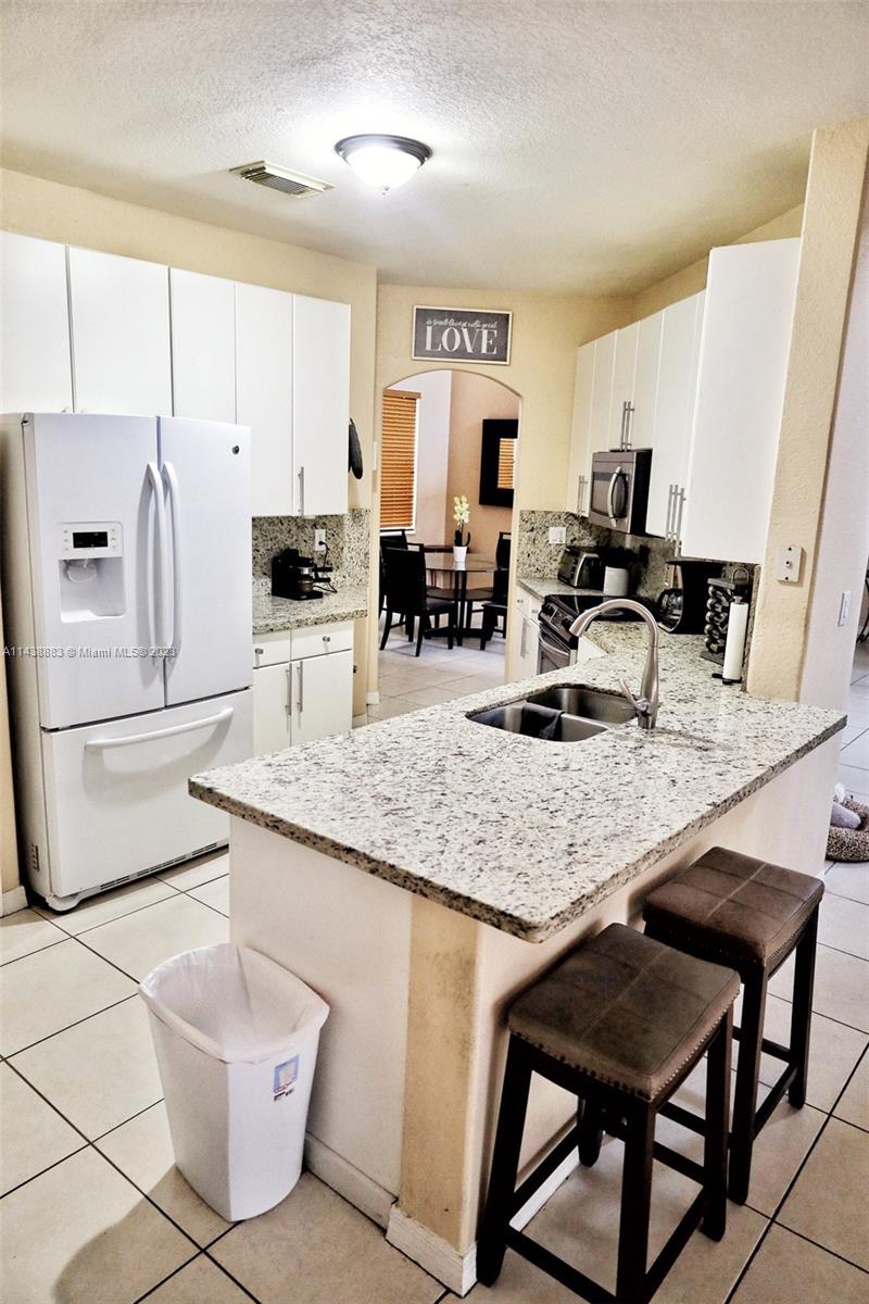 301 Southwest 87th Path Miami, FL 33174 - Photo 9 of 22 a kitchen with stainless steel appliances granite countertop a sink a stove a refrigerator cabinets and chairs