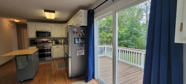 a kitchen with kitchen island wooden floor and stainless steel appliances