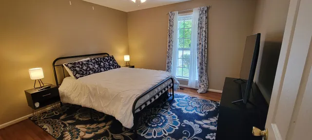 a bedroom with a bed and wooden floor