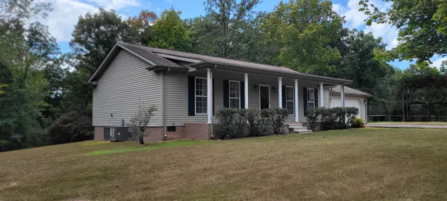 a view of a house with backyard and trees