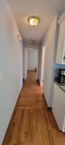 a view of a room with wooden floor and a ceiling fan