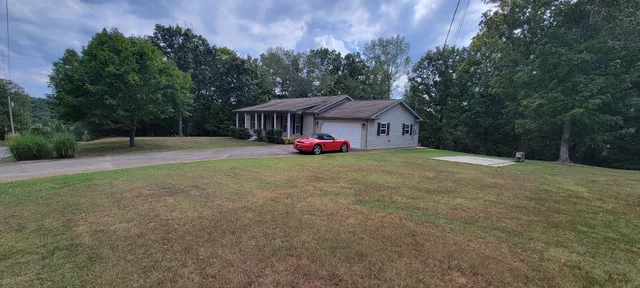 a front view of a house with a yard and trees