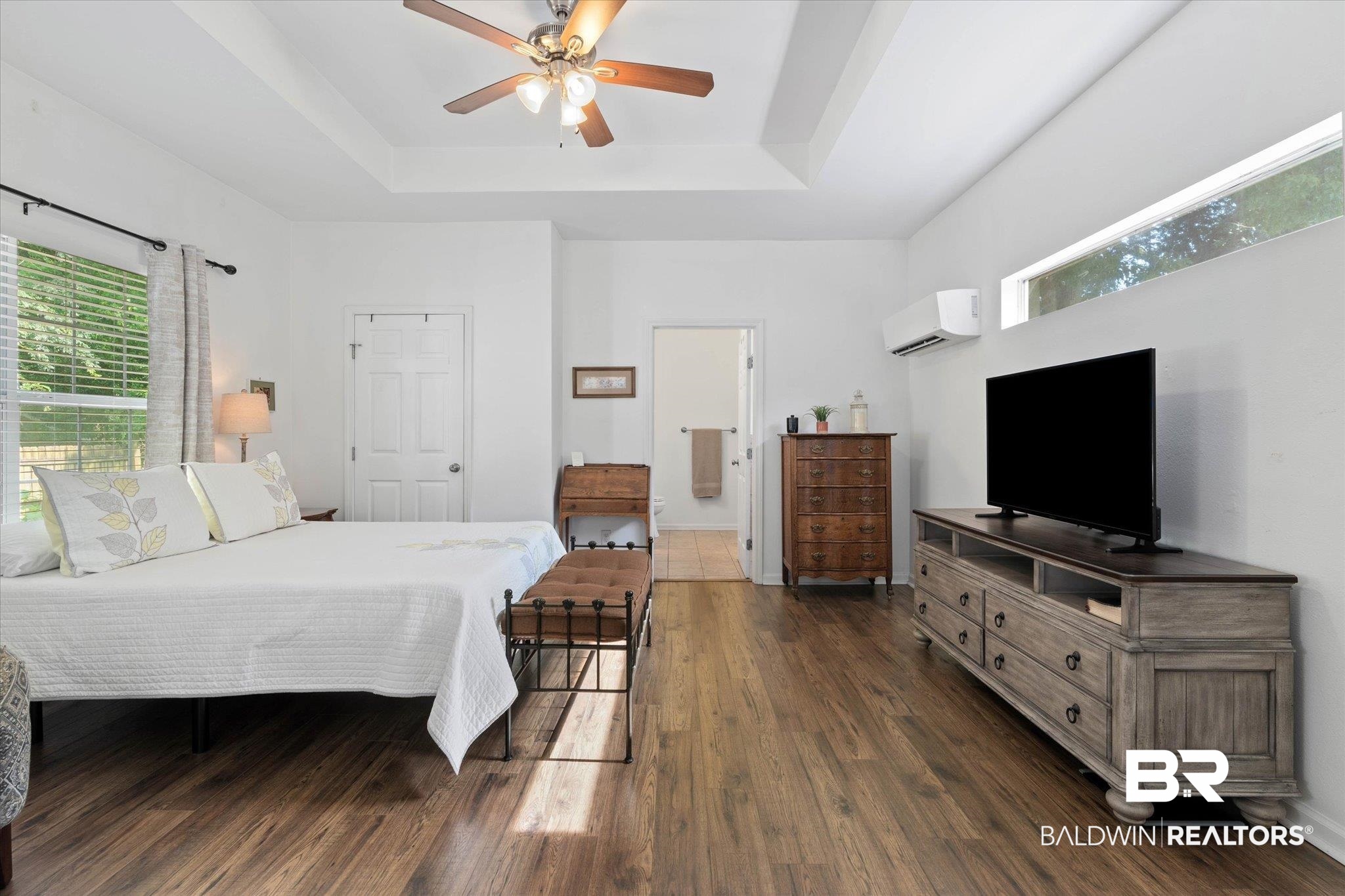 1910 Hunter Avenue Mobile, AL 36606 - Photo 11 of 21 Bedroom with a wall unit AC, a raised ceiling, dark wood finished floors, and ensuite bathroom