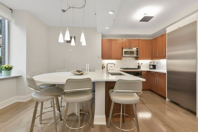 a kitchen with a dining table chairs and refrigerator