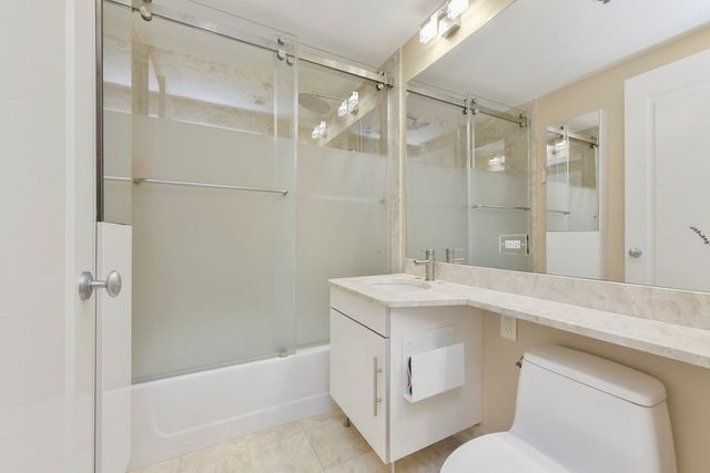a bathroom with a sink toilet vanity and shower