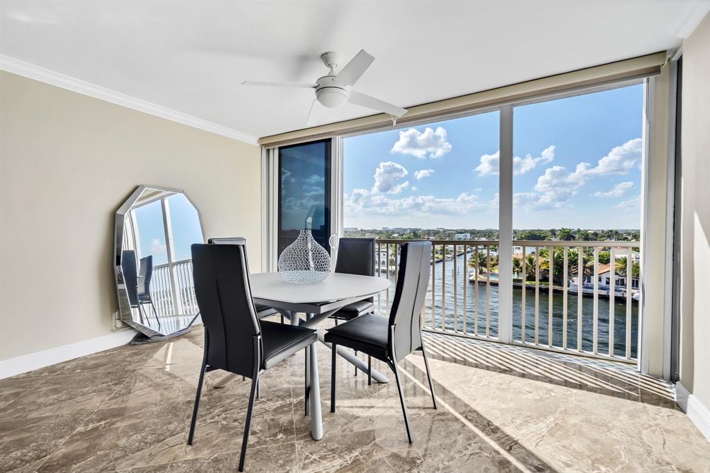 615 North Riverside Drive, Unit 702 Pompano Beach, FL 33062 - Photo 17 of 38 a view of a dining room with furniture large windows and a chandelier