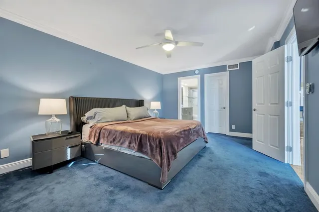 a spacious bedroom with a bed and a chandelier
