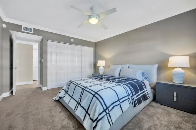 a bedroom with a bed and a lamp on dresser